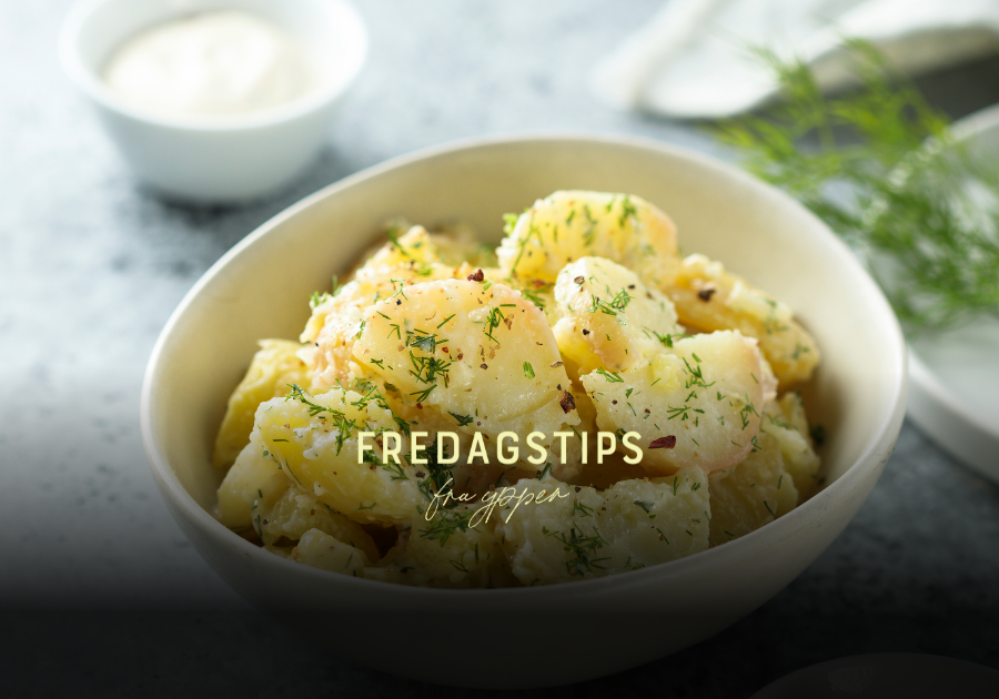Tysk potetsalat med kraft og løk, servert varm med urter på toppen.